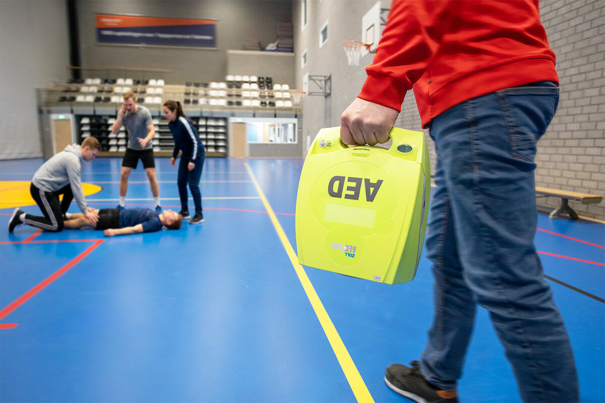 Man rent met AED naar medische situatie in een sporthal